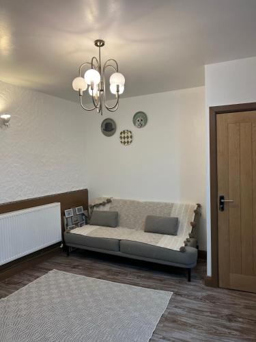 een slaapkamer met een bed en een kroonluchter bij 2 bedroom flat in Swansea