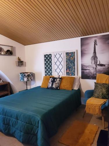 a bedroom with a blue bed and a chair at Catespero Sossego in Reguengos de Monsaraz