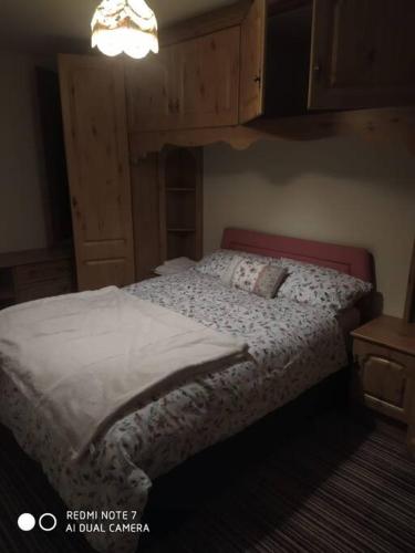 a bedroom with a bed and a chandelier at Cosy 3 Bed Retreat in Omagh in Omagh