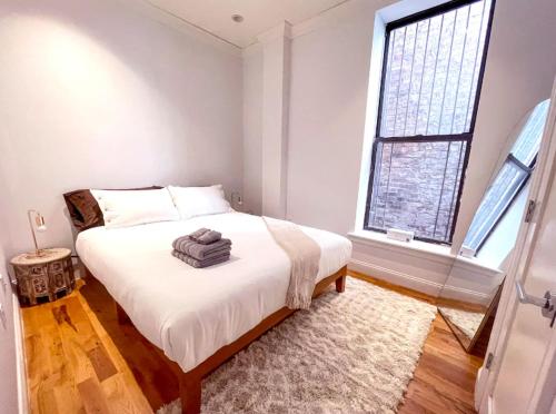 a bedroom with a large white bed and a window at Fab 3 Bedroom 1Bath Apartment in NYC! in New York