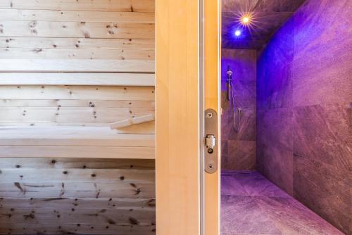 a walk in shower with a wooden wall at Plattnerhof Viums in Natz-Schabs