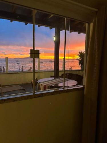 a room with a view of the ocean at sunset at Vila Alegria in Bombinhas