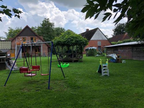 a yard with a swing set in the grass at Ferienwohnung Kalle in Osterbruch