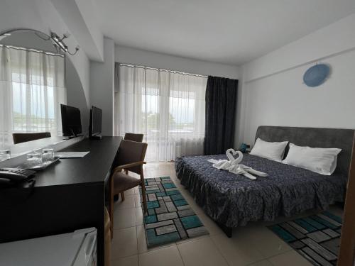 Habitación de hotel con cama, escritorio y escritorio. en Edmond, en Eforie Sud