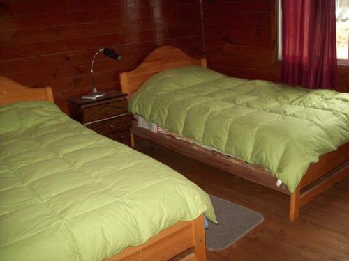 dos camas sentadas una al lado de la otra en una habitación en Hosteria Algarrobo en San Antonio