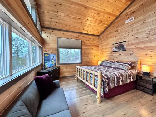 a bedroom in a log cabin with a bed and a couch at 7 BEARS Stunning views in Sevierville