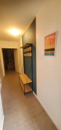 グジャン・メストラにあるT2 au cœur du bassin d'arcachonの壁に棚付きのクローゼットが備わる客室です。