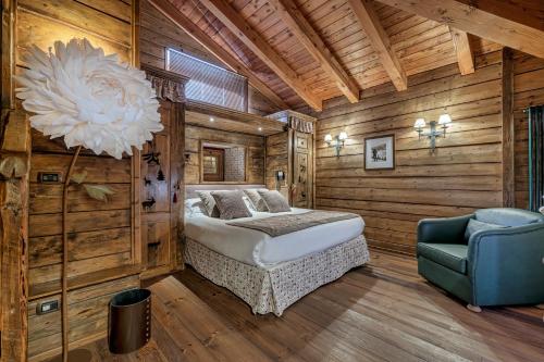a bedroom with a bed and a blue chair at Chalet BRAGARD in Limone Piemonte