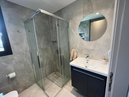 Un baño con ducha, lavabo y espejo. en Olea Valley A24 apartment, en Nikiti