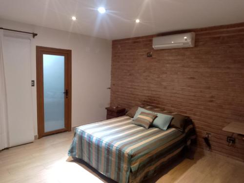 1 dormitorio con cama y pared de ladrillo en Casa amplia en ubicación tranquila de la ciudad en San Salvador de Jujuy