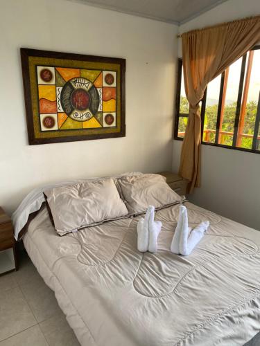 ein Bett mit zwei Paar weißen Schuhen drauf in der Unterkunft VILLA SOFI in Quimbaya