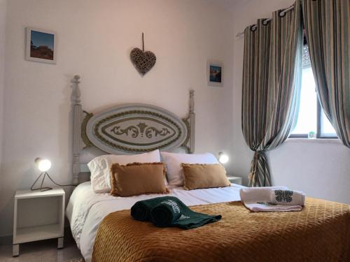 a bedroom with a bed with a heart on the wall at Casinha Garcia in Penha Garcia