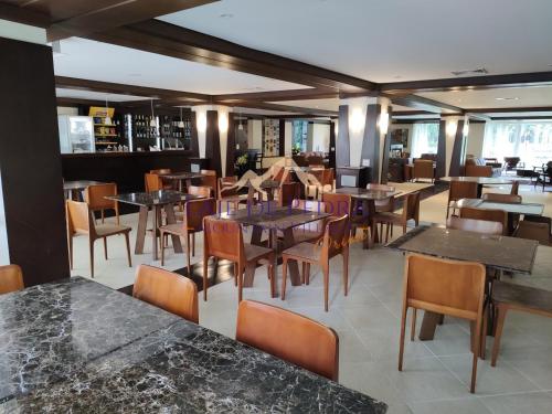 a dining room with tables and chairs and a bar at Laje de Pedra Mountain VillagePrime in Canela