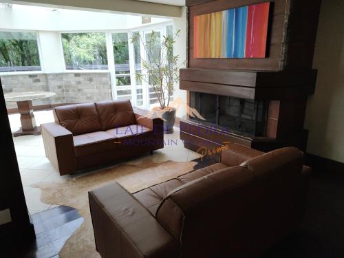 a living room with a couch and a fireplace at Laje de Pedra Mountain VillagePrime in Canela