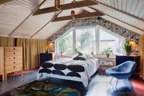 sypialnia z łóżkiem i dużym oknem w obiekcie Villa Berkle w Sztokholmie