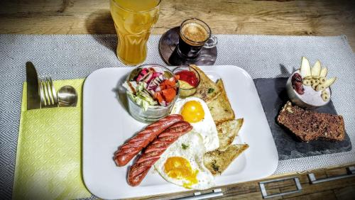 a plate of breakfast food with eggs sausage and toast at Niewielki pokój dla jednej osoby lub pary. in Warsaw