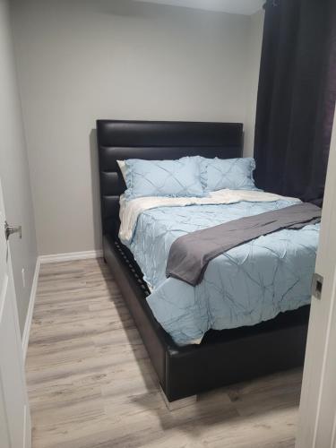 a bed with a black headboard in a bedroom at Covenant Properties in Edmonton