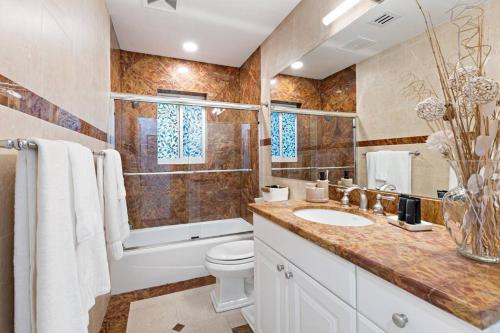 a bathroom with a sink and a toilet and a tub at Walking distance to the beach 3Br House with 1 in Fort Lauderdale