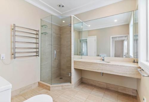 a bathroom with a shower and a sink at Sky Stars Elegant Home with Seaview in Auckland