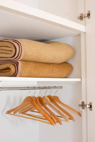 a closet with towels and wooden hangers at Hostal el Ranxo in Cadaqués