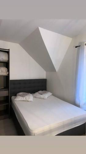 une chambre avec un lit blanc et une fenêtre dans l'établissement Agréable maison / centre historique Auxerre, à Auxerre