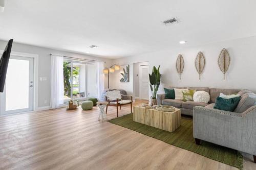 un salon avec un canapé et une table dans l'établissement Cozy home at Lighthouse Point with Pool 1, à Lighthouse Point