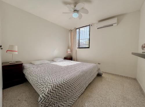 a white bedroom with a bed and a window at Nice Central Studio Apartment in Santo Domingo