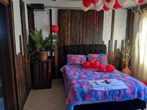 Un dormitorio con una cama con bolas rojas. en The Frailejon House, en Bogotá
