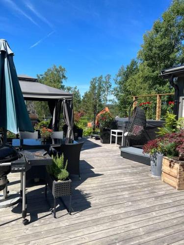 a patio with a table and an umbrella and plants at Charmig liten stuga i Södertälje/ Kungsdalen in Södertälje