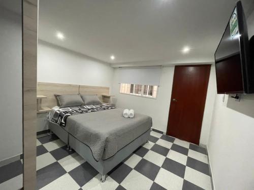 a bedroom with a bed and a checkered floor at Hostel Movistar Arena in Bogotá