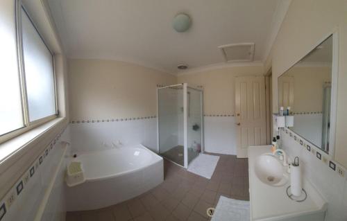 y baño con bañera, ducha y lavamanos. en A little bedroom for you (3), en Warwick Farm