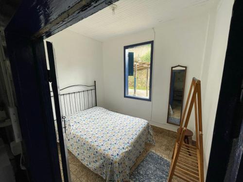 małą sypialnię z łóżkiem i lustrem w obiekcie Casa Vila 20 - Casa para temporada em Miguel Pereira w mieście Miguel Pereira