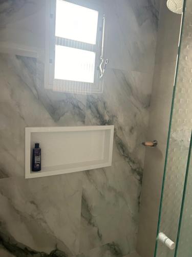 baño con ventana y pared de mármol en Casa completa - Governador Celso Ramos à 15min da praia de palmas, en Governador Celso Ramos