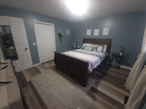um quarto com uma cama e uma parede azul em Hidden Gem close to Athens/Logan em Nelsonville