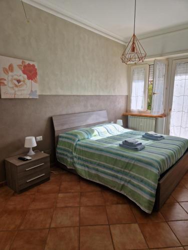 Un dormitorio con una cama grande y una mesita de noche. en Alloggio Turistico 3 minuti da aeroporto- Fiumicino centro, en Fiumicino