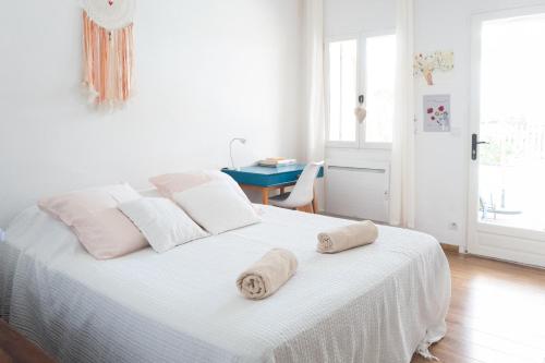 une chambre blanche avec un lit avec des serviettes dessus dans l'établissement Maison Lauris, à Lauris