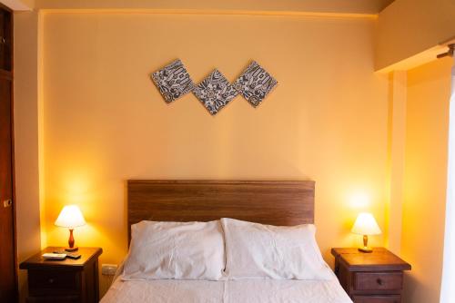 a bedroom with a bed with two nightstands and two lamps at Complejo Berilde I in San Clemente del Tuyú
