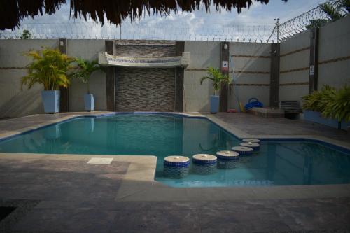 een zwembad met een rij krukken eromheen bij Casa Campo Villa Rosa in Valledupar