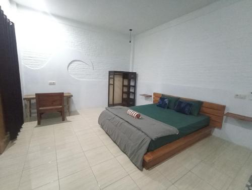 Un dormitorio con una cama y una mesa. en Ayolah surf House & Medewi Surf Camp, en Jembrana