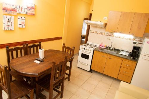 a kitchen with a wooden table and a kitchen with a stove at Complejo Berilde I in San Clemente del Tuyú