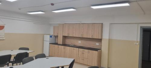a room with tables and chairs and a kitchen at 데브레첸 마미손 / Mamison Hostel Debrecen in Debrecen