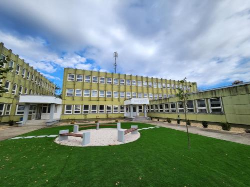 un gran edificio con un césped verde delante de él en 데브레첸 마미손 / Mamison Hostel Debrecen, en Debrecen