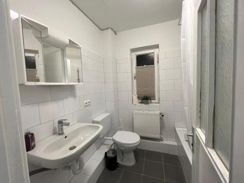 "Live Good, Work Good" Central House by GG Rental Hamburg في Schenefeld: حمام أبيض مع حوض ومرحاض