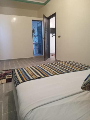 a large bed in a room with a doorway at Appartement Hassilabiad-Erg Chebbi in Hassilabied