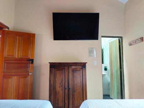 a bedroom with a flat screen tv on the wall at Hotel PiedradeLuna in Villa de Leyva