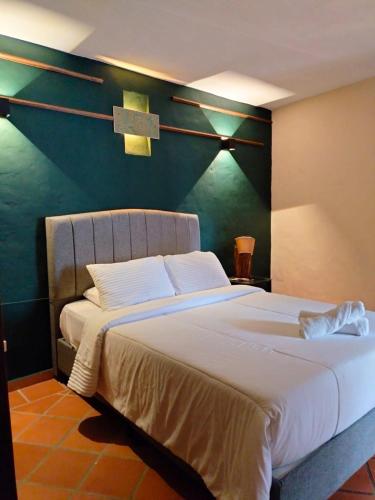 a bedroom with a large bed with a cross on the wall at Hotel PiedradeLuna in Villa de Leyva