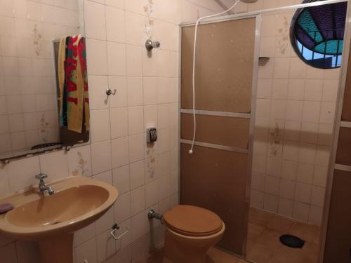 a bathroom with a toilet and a sink and a shower at Pousada Arvoredo in Contagem