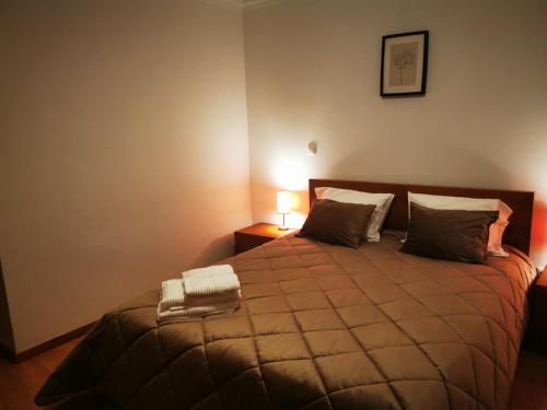 una camera da letto con un grande letto con due cuscini di Casa da Escola a Paredes de Coura