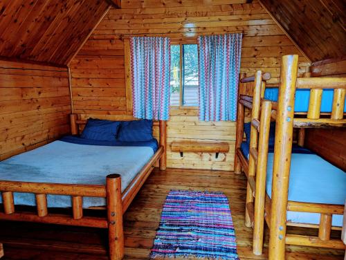 1 dormitorio con 2 literas en una cabaña de madera en Kingman KOA, en Kingman