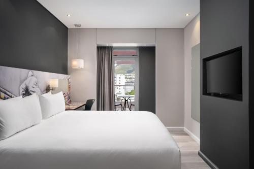 a hotel room with a bed and a television at Protea Hotel Fire & Ice by Marriott Cape Town in Cape Town